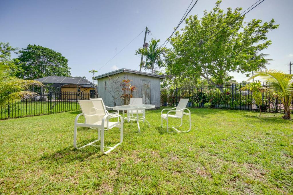 Dos sillas y una mesa en un patio. en Less Than 3 Mi to Hard Rock Stadium Miami Home with Sunroom, en Miami