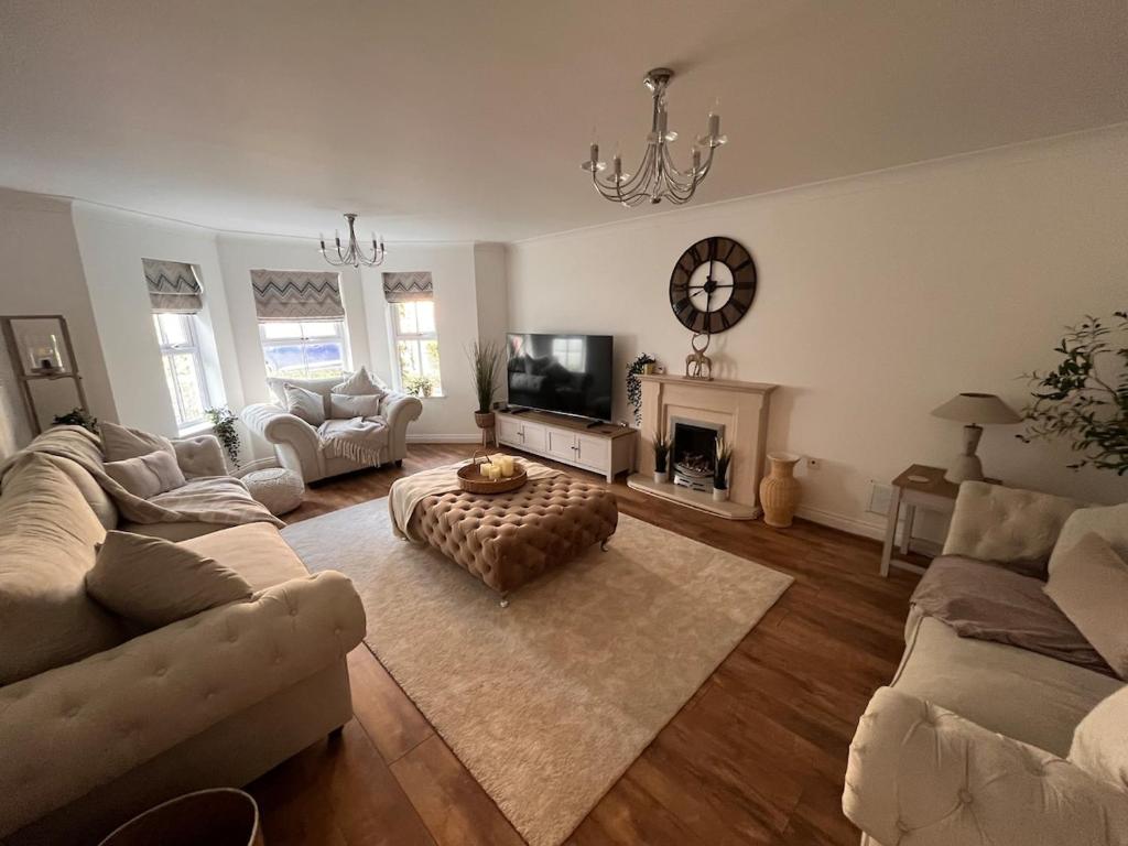 ein Wohnzimmer mit Sofas, Fernseher und Kamin in der Unterkunft Elegant 5 Bed 5 Bath Home in Englefield Green