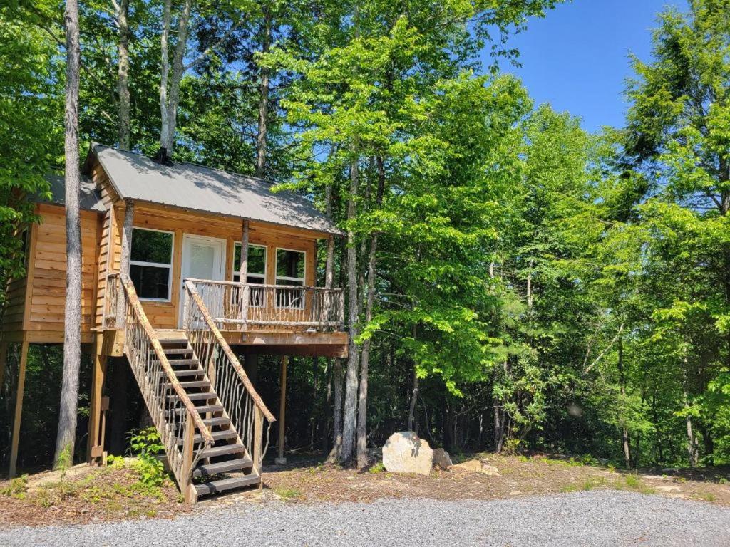 a tree house in the woods with a staircase at Treehouses at Lake Mountain Manor in Princeton