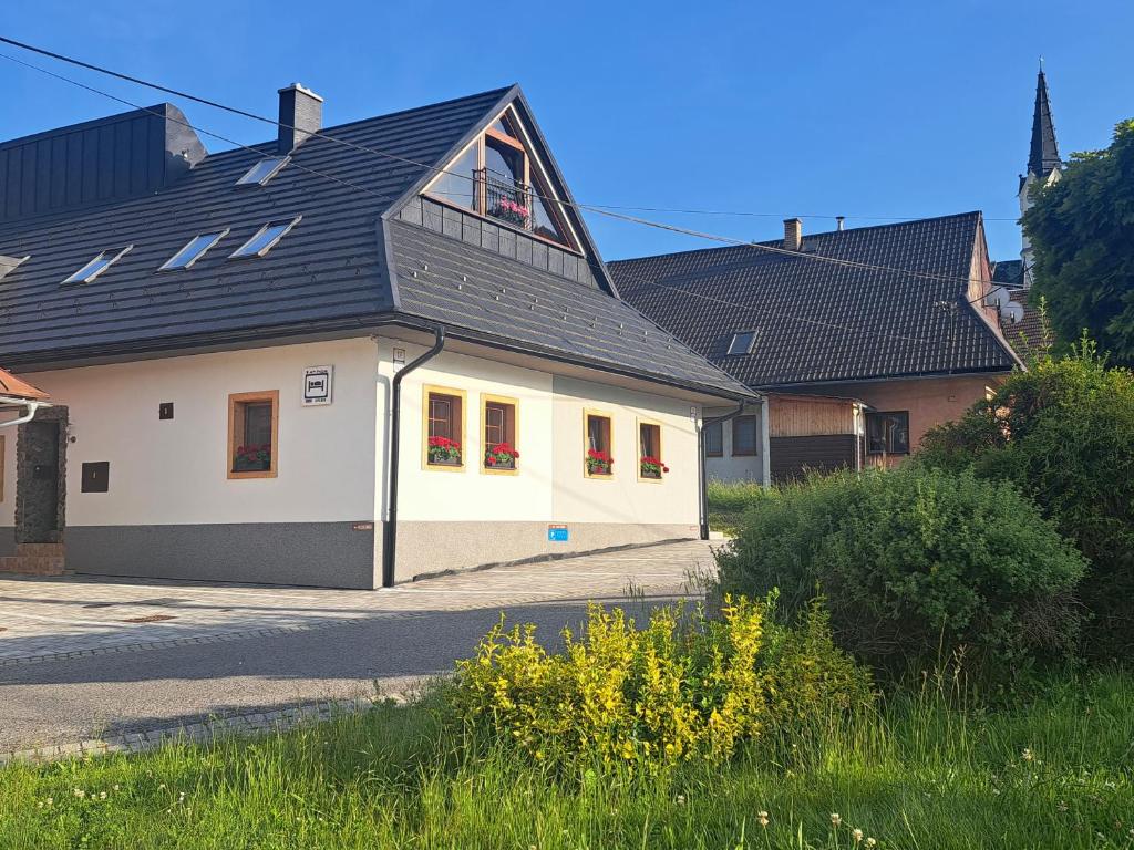 ein weißes Haus mit einem schwarzen Dach in der Unterkunft Privat LeNa in Ružomberok