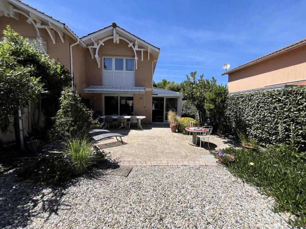 une maison avec une terrasse et un bâtiment dans l'établissement Résidence Les Arros - 087 - Charmante maison sur 2 niveaux aux Arros MAE-6121, à Soulac-sur-Mer