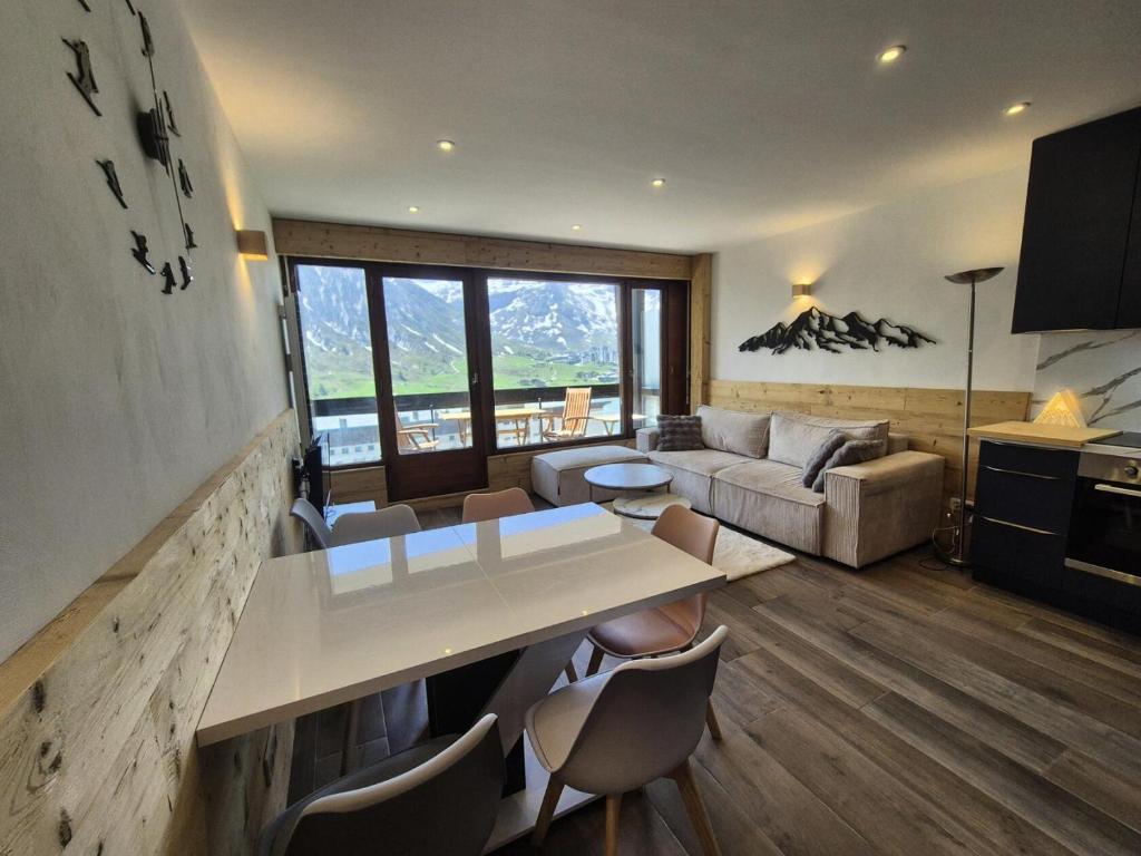 un salon avec une table et des chaises blanches dans l'établissement Résidence Bec Rouge - Appartement rénové·Skis aux pieds·Balcon MAE-6213, à Tignes