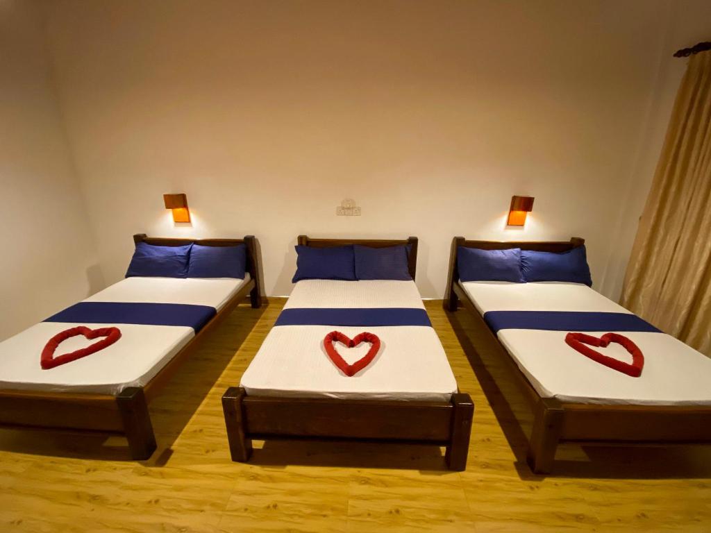 two beds with hearts painted on them in a room at Oasis Bay - Arugam Bay in Arugam Bay