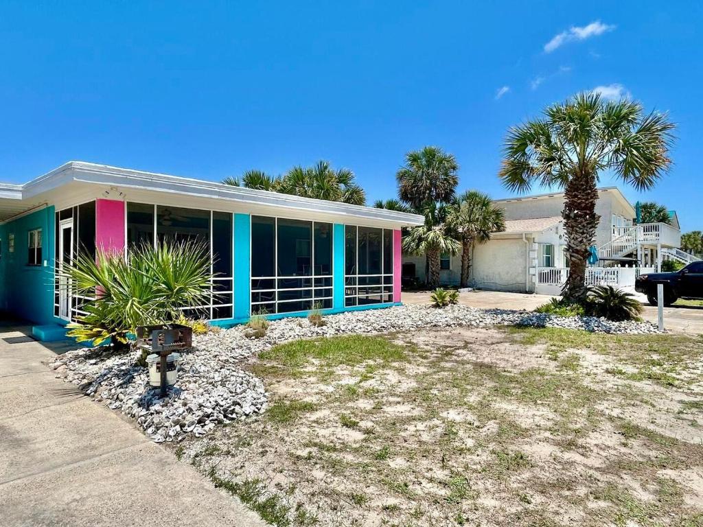 a house with palm trees in front of it at Vice in St. George Island
