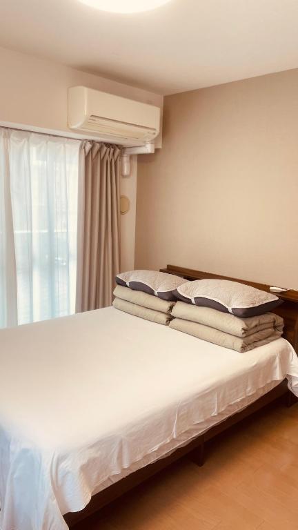 Postel nebo postele na pokoji v ubytování SkyHotel Ryogoku 駅徒歩4分