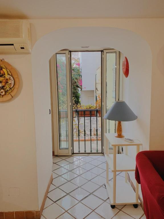 a living room with a table with a lamp on a floor at Pied-à-Terre in Piazzetta in Capri