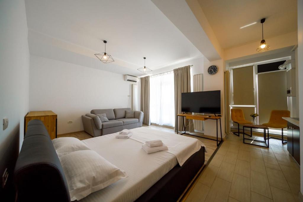 een slaapkamer met een groot bed en een woonkamer bij SeaZen Studio in Mamaia Nord – Năvodari