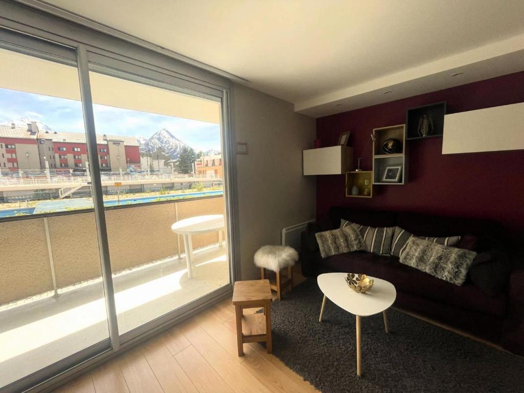 un salon avec un canapé et une grande fenêtre dans l'établissement Résidence Vallee Blanche - Superbe studio contemporain au cœur de station MAE-5281, à Vénosc