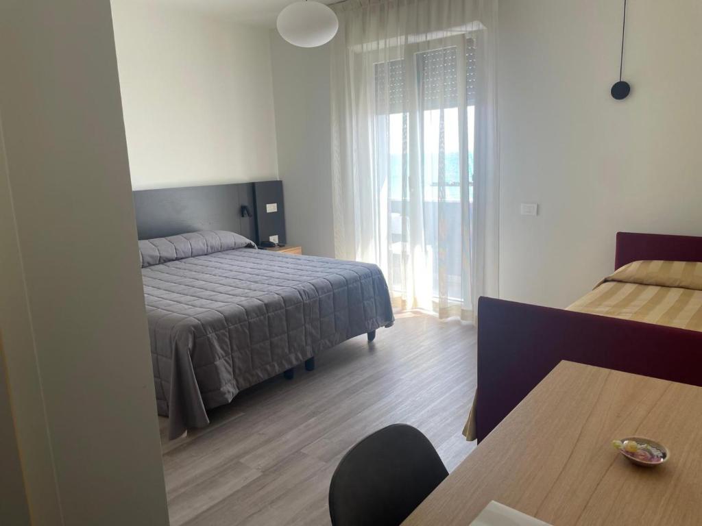 sypialnia z łóżkiem i stołem w obiekcie Hotel Il Caminetto w mieście Porto San Giorgio