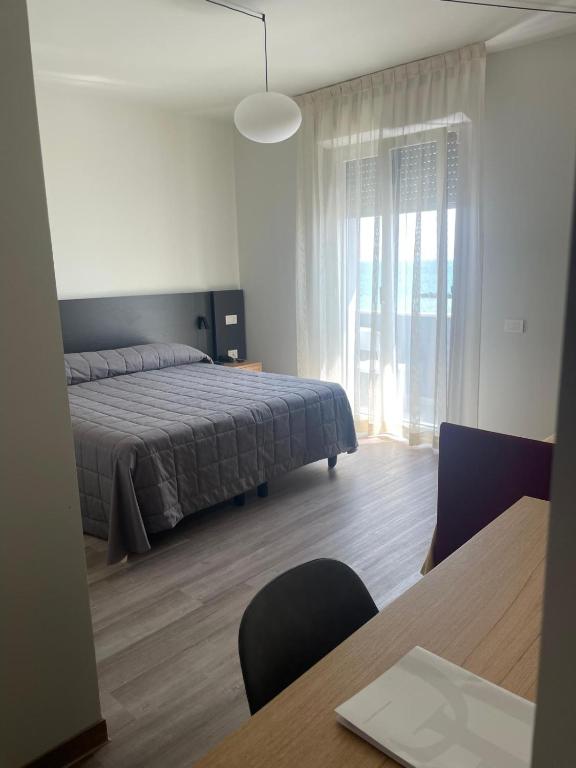 sypialnia z łóżkiem i stołem z krzesłami w obiekcie Hotel Il Caminetto w mieście Porto San Giorgio