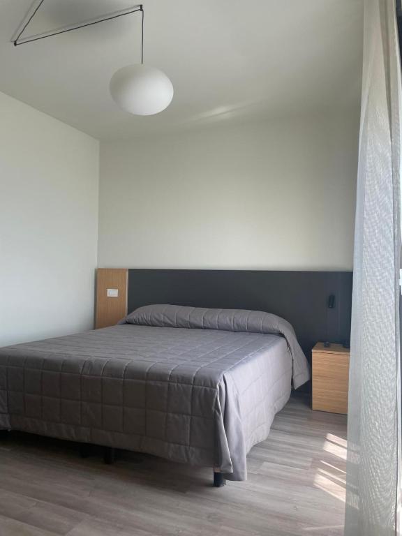 sypialnia z łóżkiem i białą ścianą w obiekcie Hotel Il Caminetto w mieście Porto San Giorgio