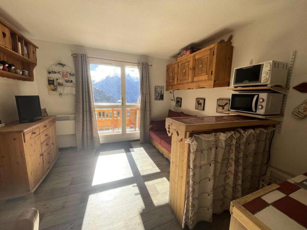 une cuisine avec des placards en bois et une fenêtre avec vue dans l'établissement Résidence Pleiades - Appartement style montagne avec vue dégagée sur la station et les montagnes dans un secteur calme MAE-5571, à Vénosc