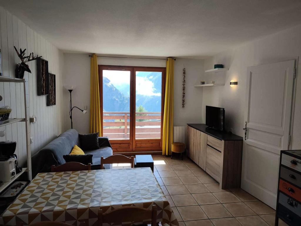 un salon avec un canapé et une télévision dans l'établissement Résidence Prince Des Ecrins - Spacieux appartement 4 couchages secteur calme avec vue spectaculaire MAE-5601, à Vénosc