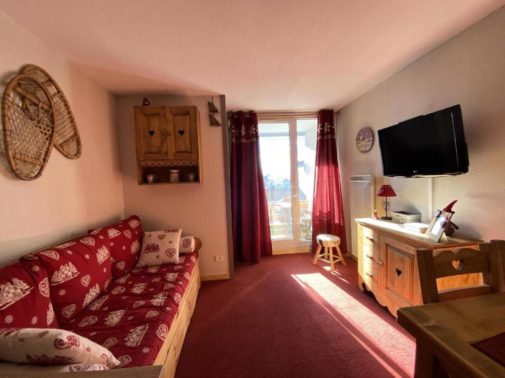 un salon avec un canapé rouge et une télévision dans l'établissement Résidence Galibier Iii - Jolie T2 au pieds des pistes MAE-5651, à Vénosc