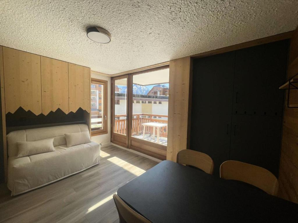 un salon avec un canapé et une grande fenêtre dans l'établissement Résidence Alberges - T2 de 4 couchages au cœur de la station des Deux Alpes MAE-7621, à Vénosc