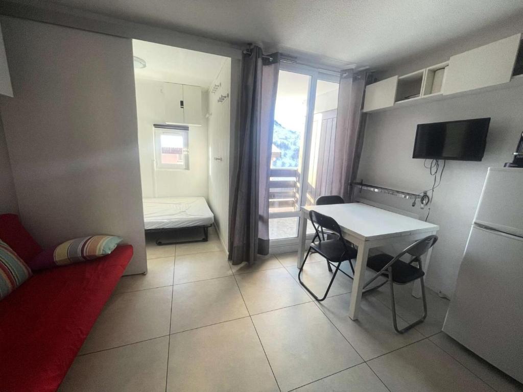 une petite chambre avec une petite table et une cuisine dans l'établissement Résidence Arc En Ciel B - T2 cosy à proximité du départ des pistes, vue sur la montagne MAE-0551, à Vénosc