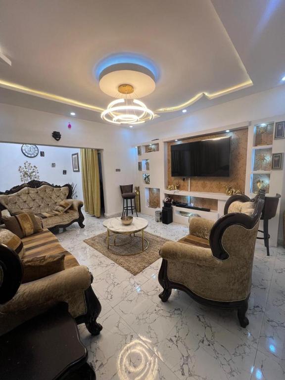 a large living room with couches and a tv at Luxury 3 Bedroom Bungalow in Enugu