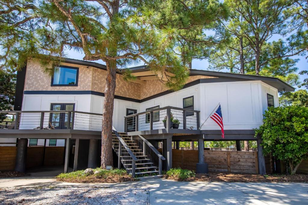 a house with an american flag in front of it at Dune Allen Treehouse in Santa Rosa Beach