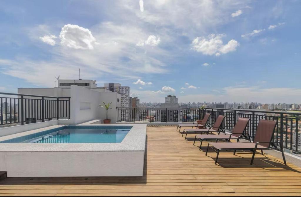 a balcony with chairs and a swimming pool on a building at 74NV Studio Liberdade SP 300 metros Estação Metrô Japão até 03 pessoas in Sao Paulo