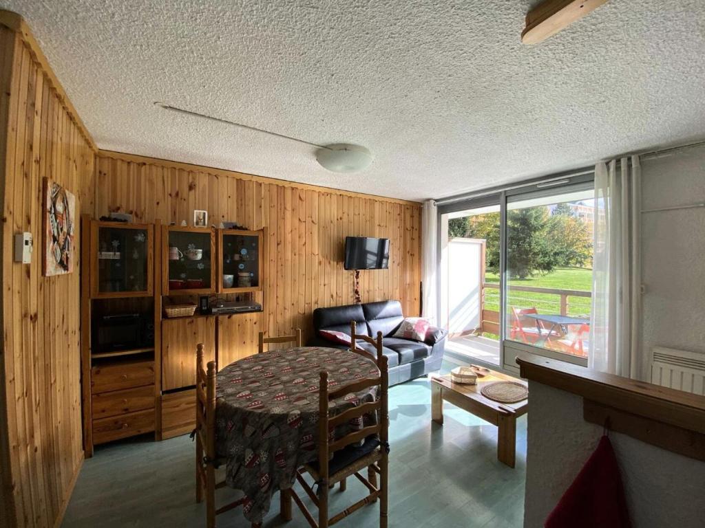 un salon avec une table et un canapé dans l'établissement Résidence Cote Brune 5 - Studio pour 5 Personnes 551, à Vénosc