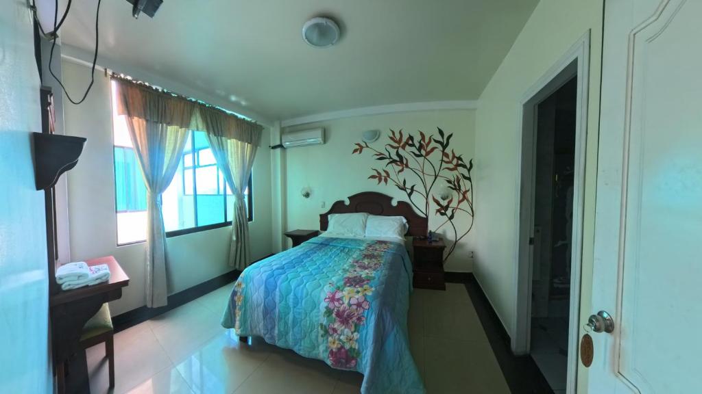 a bedroom with a bed and a window at Hotel Delfin Rosado in Puyo