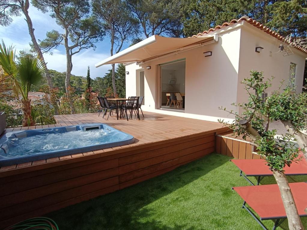 a backyard with a hot tub on a wooden deck at Maison T2 avec jacuzzi in Ensuès-la-Redonne