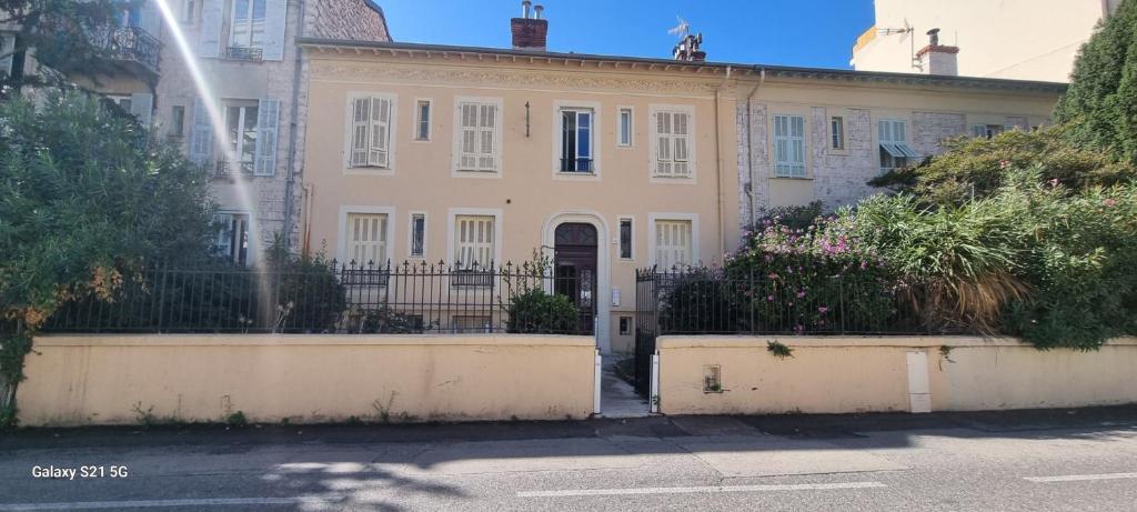 une grande maison blanche avec une clôture devant elle dans l'établissement Appartement 1 chambre, à Nice
