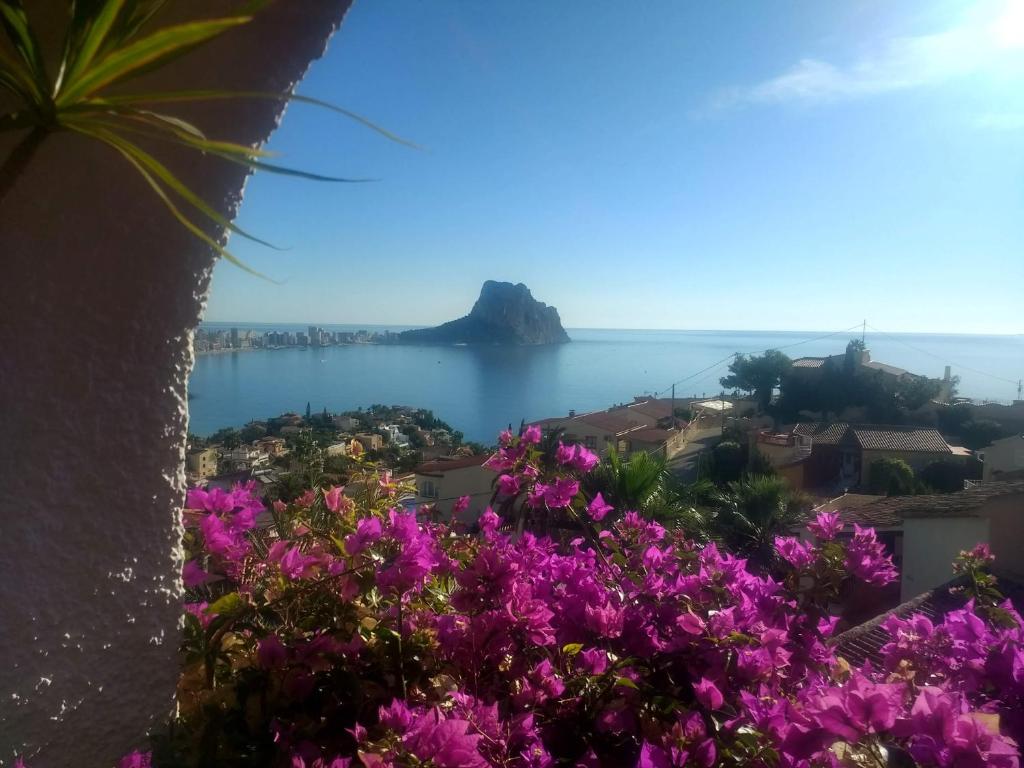 un balcón con vistas al océano y flores púrpuras en Europlaya Atico, en Calpe
