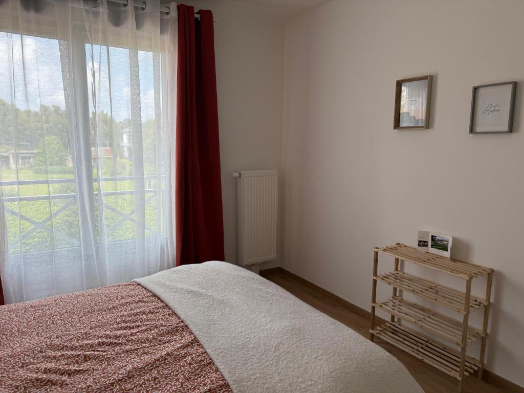 a bedroom with a bed and a large window at Chez Moumoune in Saint-Valéry-en-Caux