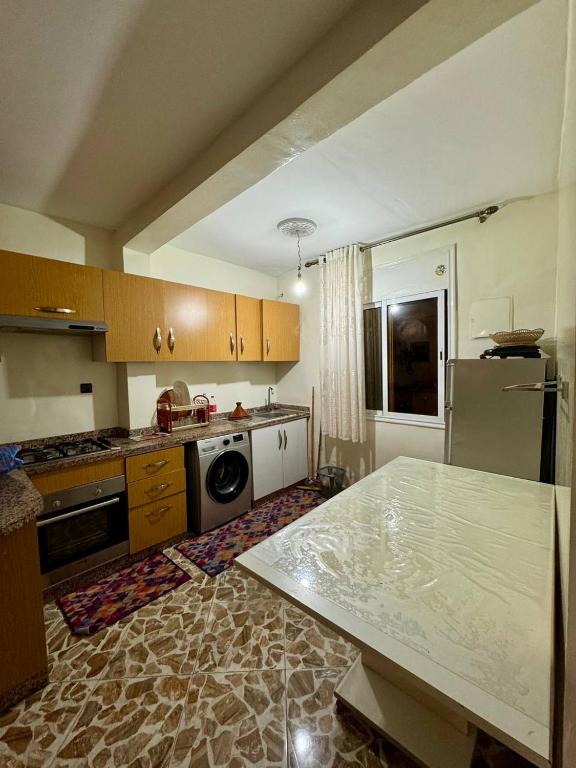 a kitchen with a stove and a refrigerator at Appartement Vue Mer Tamraght in Tamraght Oufella