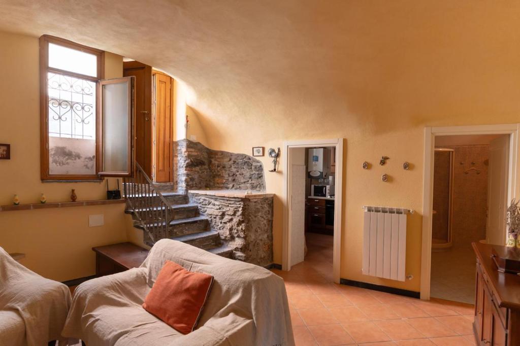 a living room with a couch and a staircase at La Prebeluna da Ceve in Pieve di Teco