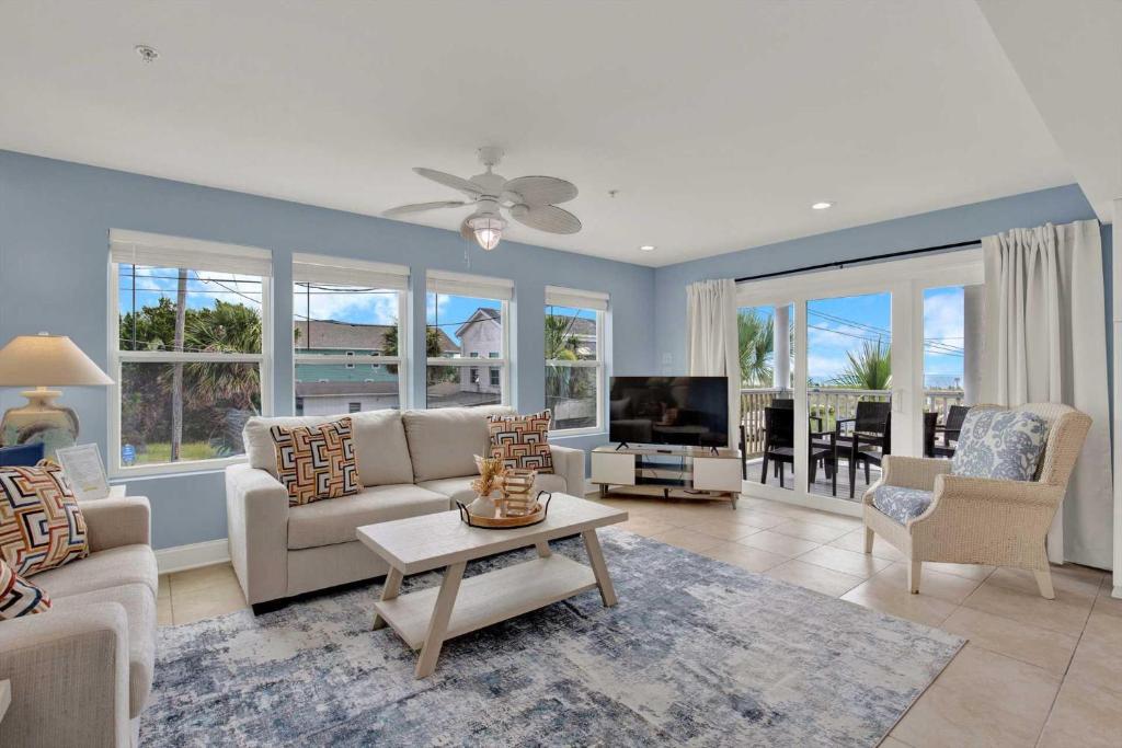 a living room with a couch and a tv at Oceanview on Tybee 202-1 in Tybee Island