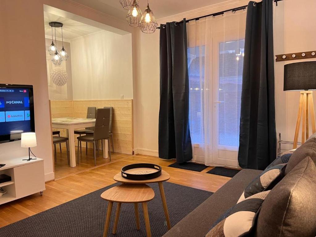 ein Wohnzimmer mit Sofa und Tisch in der Unterkunft Maison La Belle Endormie- Disneyland et Paris in Champs-Sur-Marne
