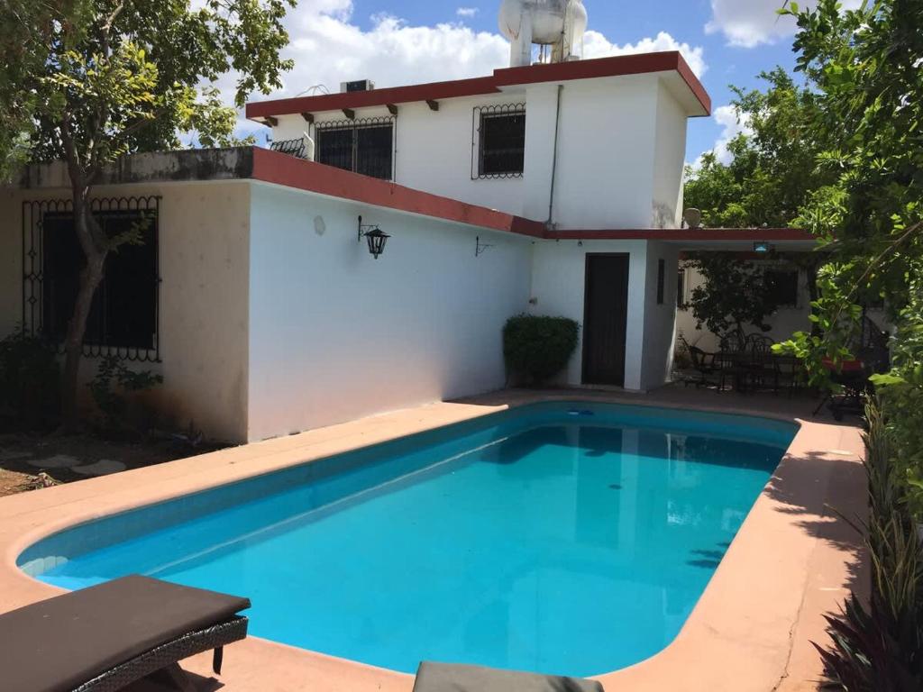 a villa with a swimming pool in front of a house at Amplio loft 6 pax cerca de Paseo de Montejo in Mérida