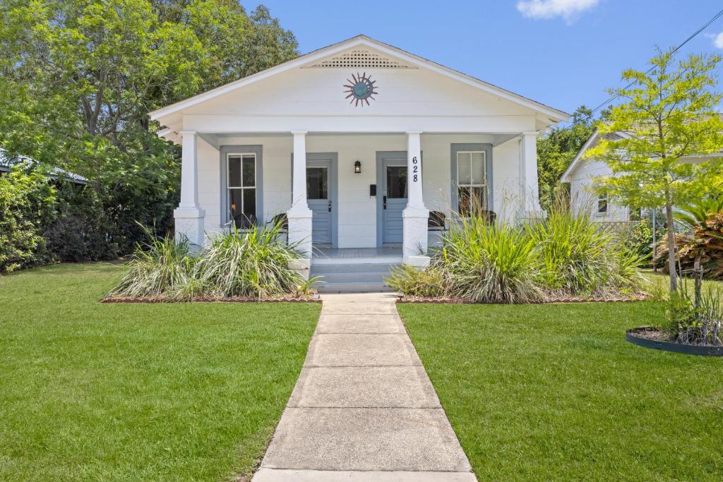 una casa bianca con un prato verde di Gulfport Game Room House Walk to Beach Family Fun a Gulfport
