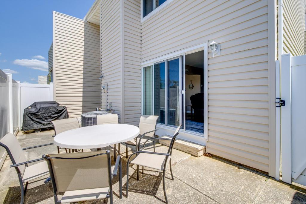a patio with a white table and chairs at Walk to Brigantine Beach Condo with Furnished Patio in Brigantine