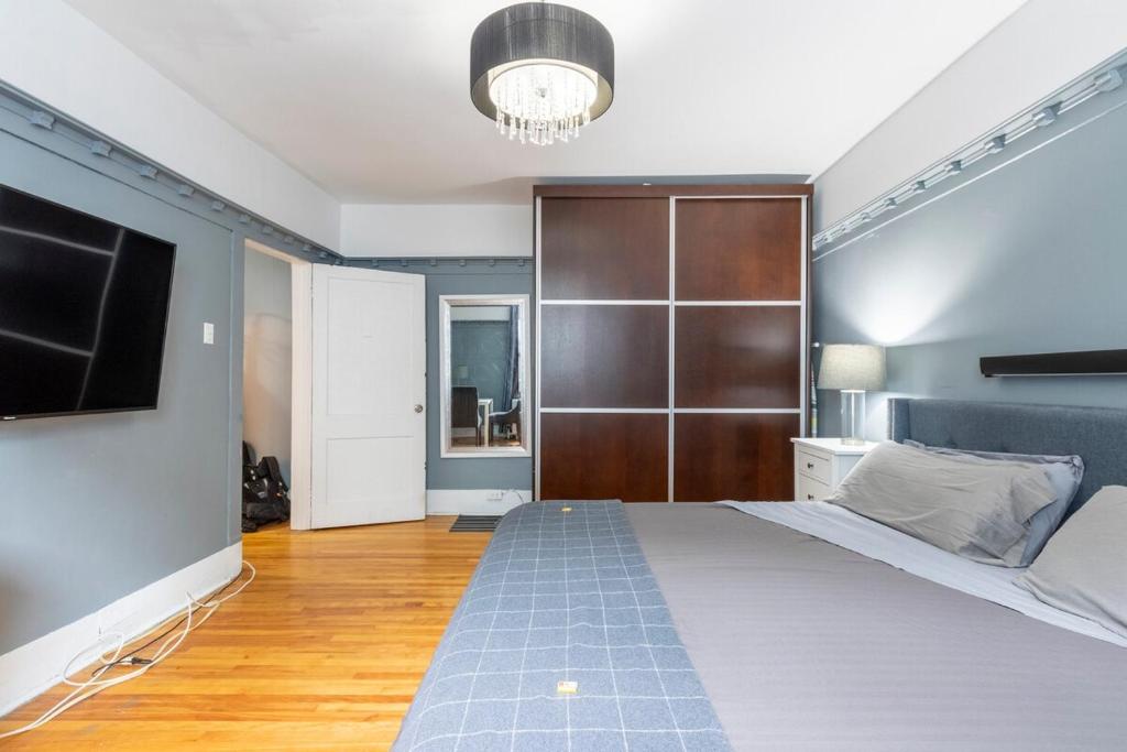 a bedroom with a large bed and a television at Huge King Room in 3 BedRoom Great Location Downtown Mtl in Montréal