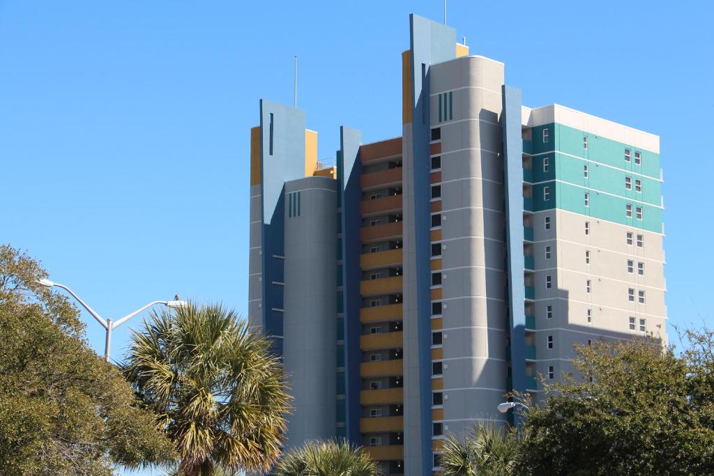 a tall building with palm trees in front of it at Atlantica Resort III in Myrtle Beach