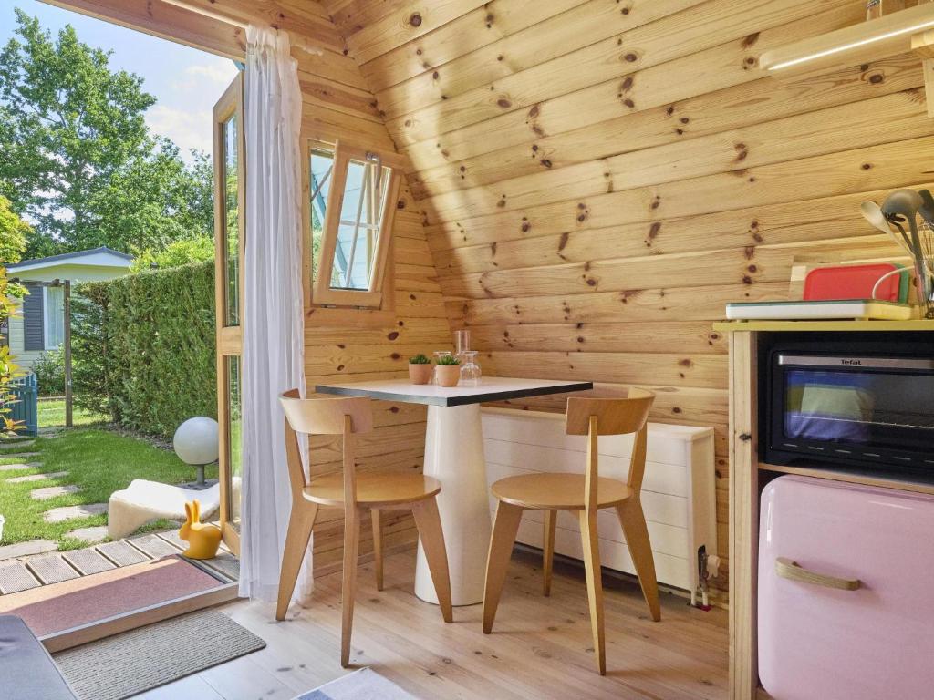 una piccola cucina con tavolo e sedie in una casetta di Tiny House Jet a Goedereede
