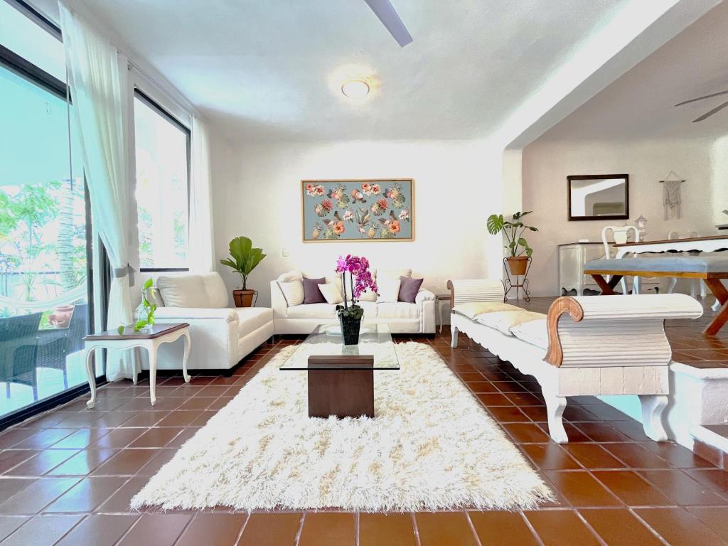 Una sala de estar con muebles blancos y un piano. en The Villa of Dreams, en Cancún