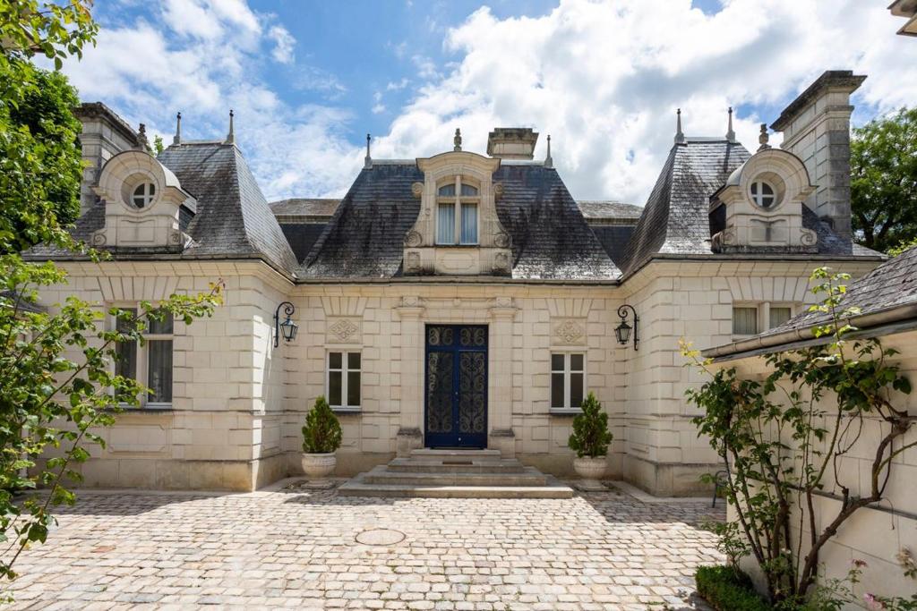 une grande maison en pierre avec une porte bleue dans l'établissement Palais D’Or, à Loches