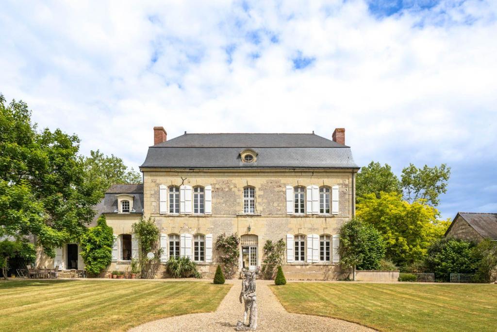 une grande maison en pierre avec une grande cour dans l'établissement Manoir Des Arts, à Allonnes