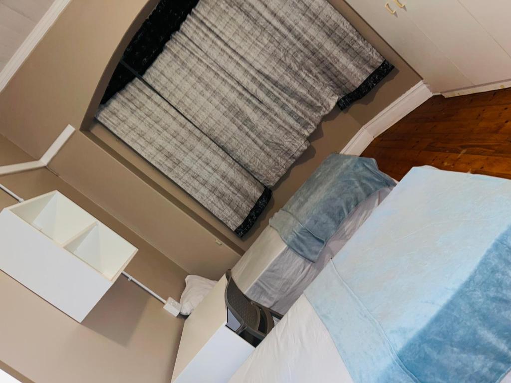 a small room with a bed and a window at Bulwer Breeze Guesthouse in Durban