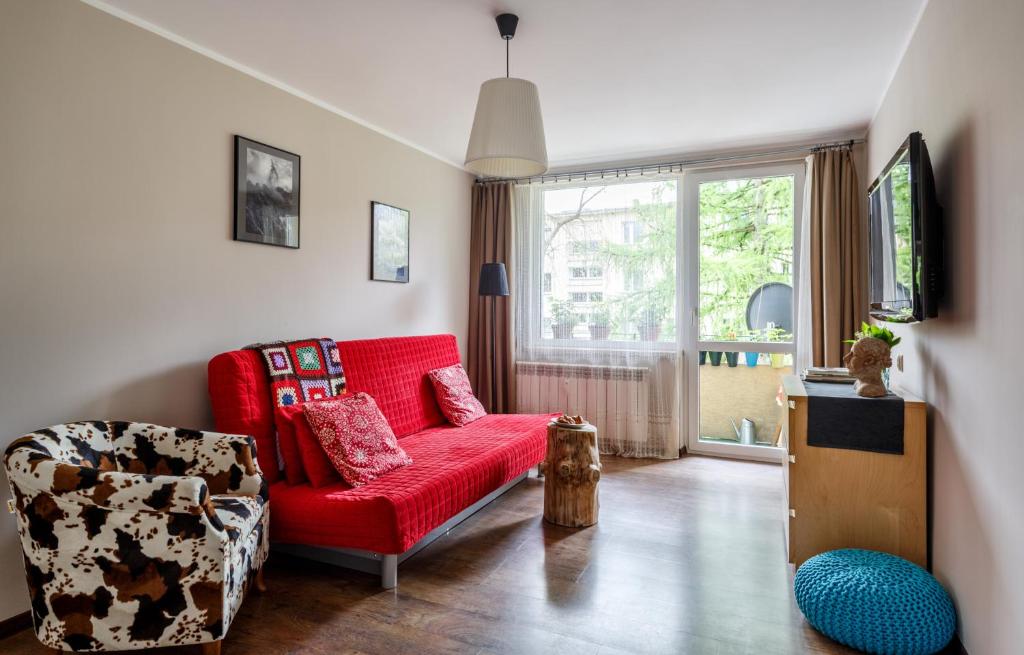 a living room with a red couch and a chair at Apartament Tosia Zakopane in Zakopane