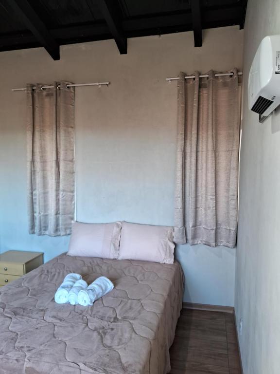 a bedroom with a bed with two blue pillows at Pousada Siriemas in Cambara do Sul