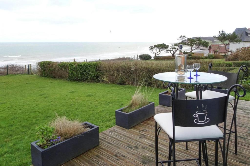 - une table et des chaises sur une terrasse avec vue sur la plage dans l'établissement Holiday Home in Quiberville with Sea Views, cleaning included, à Quiberville