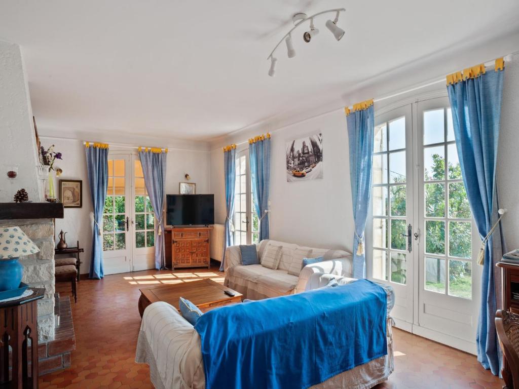 - un salon avec des rideaux bleus et un canapé dans l'établissement Villa in Velines with Garden and Wine Tours, cleaning included, à Vélines