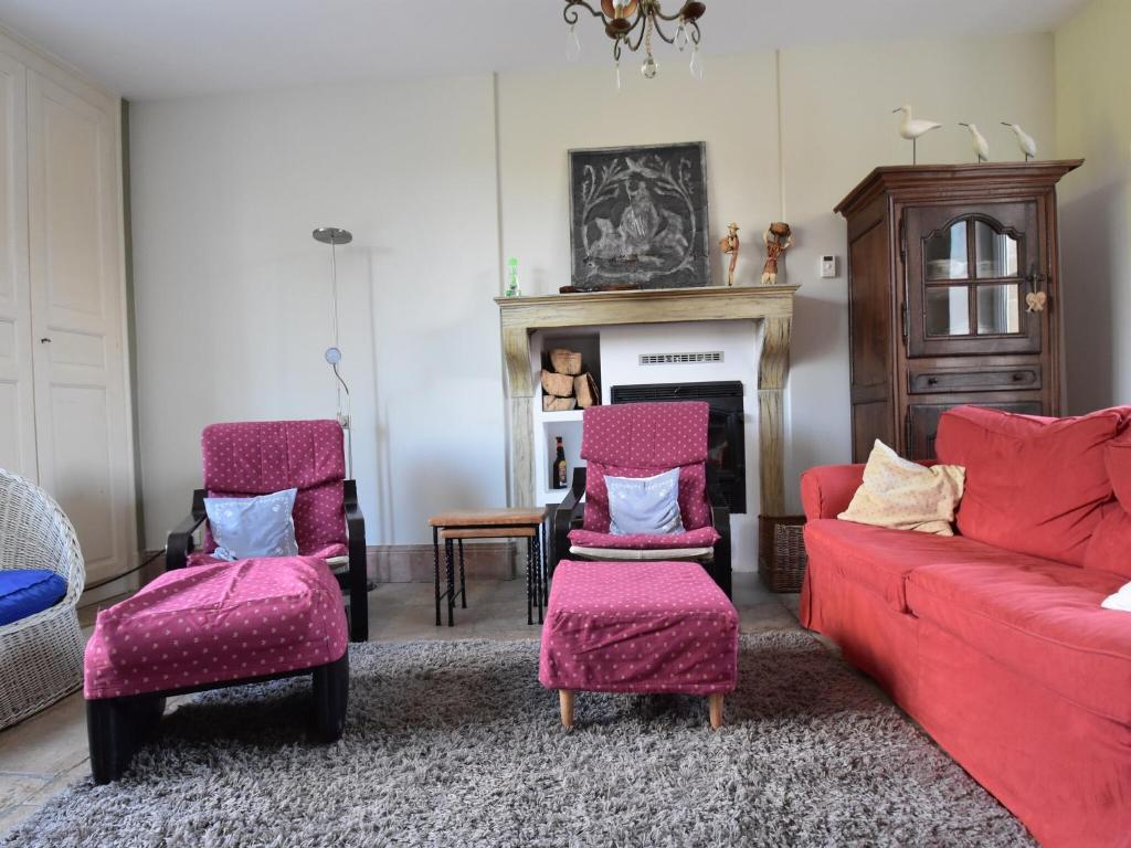un salon avec un canapé rouge et deux chaises dans l'établissement Holiday Home Channay with Pool & Sauna, cleaning included, à Villiers-les-Moines