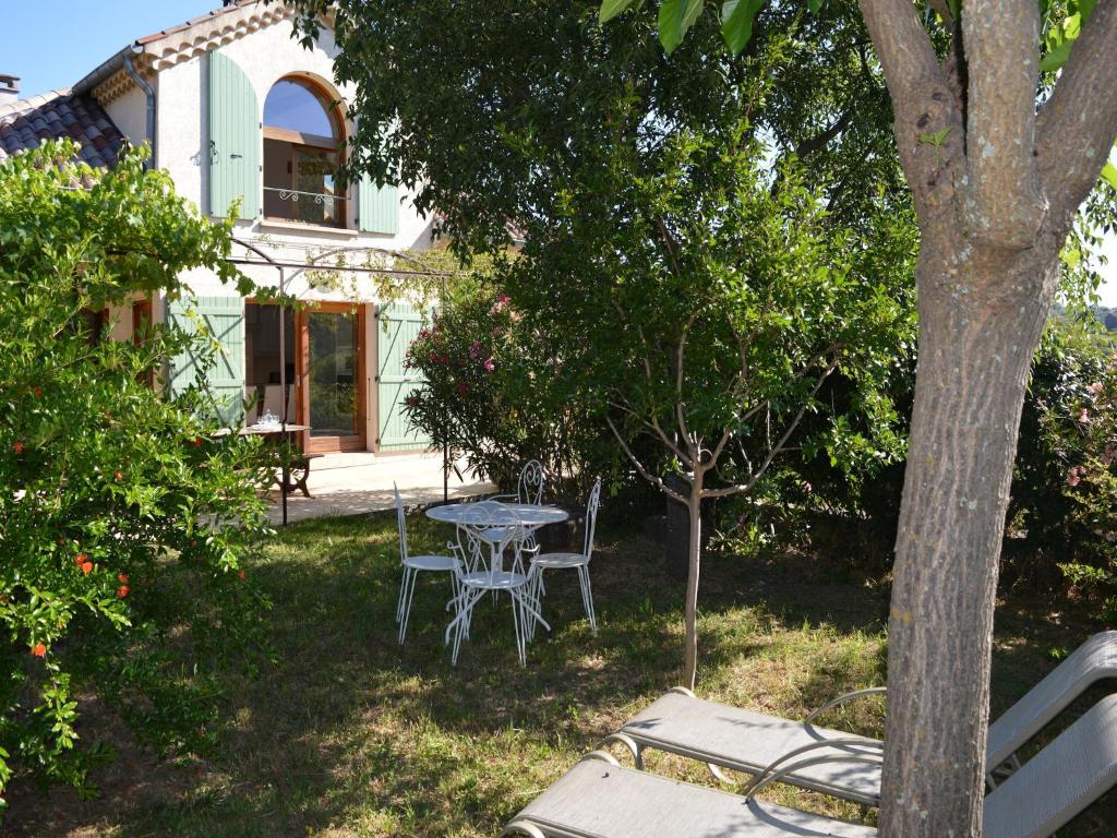 - une table et des chaises dans la cour d'une maison dans l'établissement Holiday Home in Les Vans near Bois de Païolive, cleaning included, aux Vans