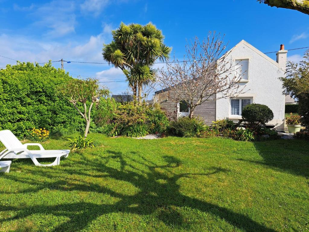 une chaise blanche assise dans la cour d'une maison dans l'établissement Holiday Home in Cléder near Amiets Beach, cleaning included, à Cléder
